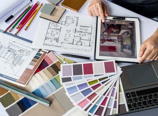 Top view of architects/ interior designer hands working with tablet computer, material sample on desk